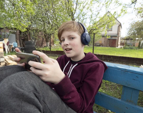 Vit Pojke Spelar Smartphone Sitter Trädgården — Stockfoto