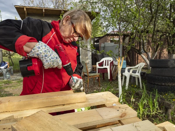 Senior Caucasian Woman Assembles Wooden Frame Building Using Metal Fasteners — Stock Photo, Image