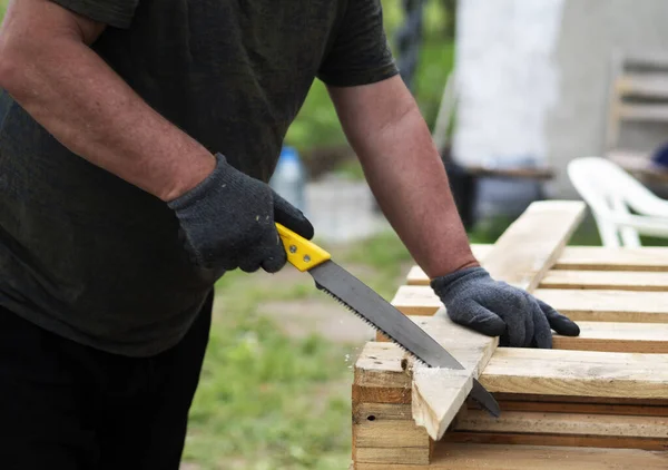 Manos Hombre Caucásico Aserrando Una Tabla Pino Jardín —  Fotos de Stock