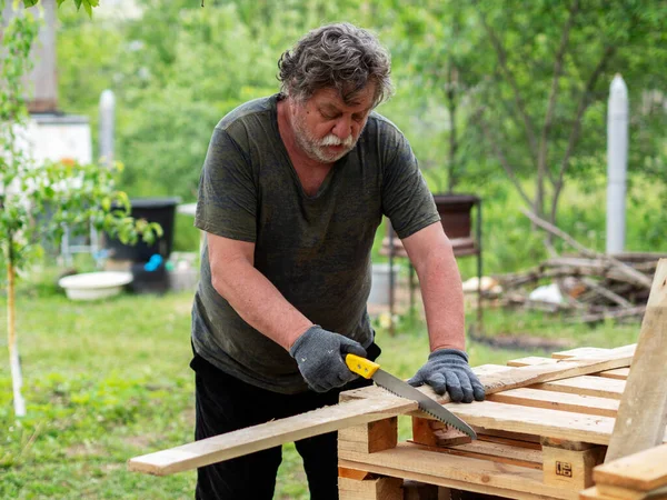 Mature Caucasian Man Sawing Pine Board Garden — Stock Photo, Image