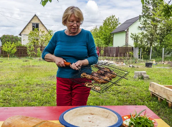 Старшая Белая Женщина Режет Курицу Барбекю — стоковое фото