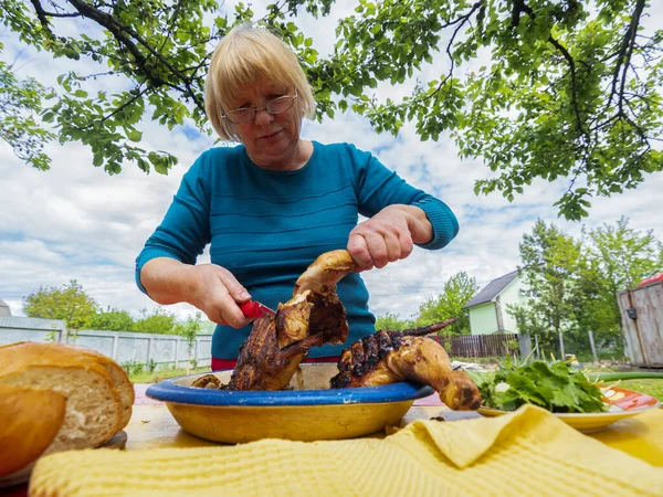 Starsza Kaukaska Kobieta Tnie Kurczaka Grilla — Zdjęcie stockowe