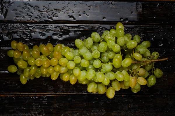 A bunch of grapes on a wooden background — Stock Photo, Image