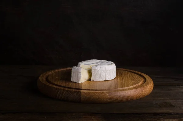 Rueda de queso sobre tabla de madera — Foto de Stock