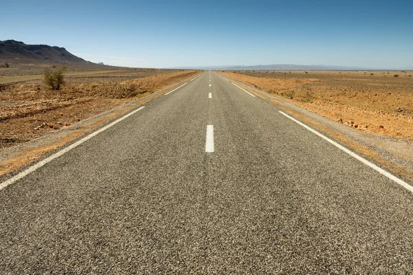 Asfaltowa droga na skalistej pustyni — Zdjęcie stockowe