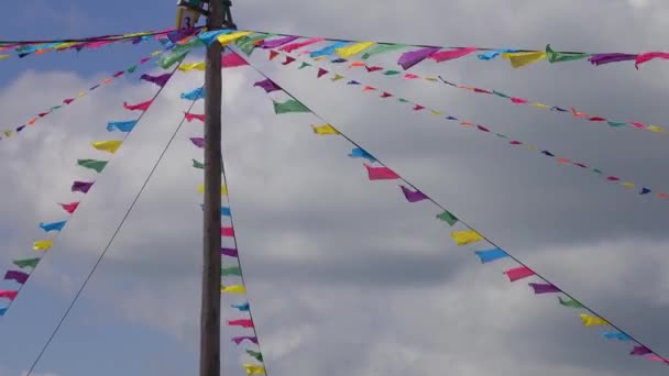 Lange paal met kleurrijke driehoekige vlaggen op touwen — Stockvideo