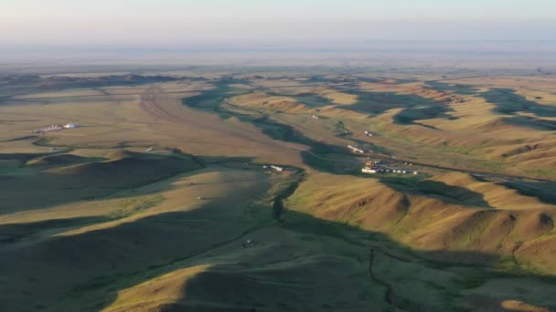 Moğolistan 'da gün batımında anıtlar arasındaki yurtlar — Stok video