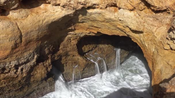 Grote golven komen door een gat in de rotsen van de Algarve — Stockvideo