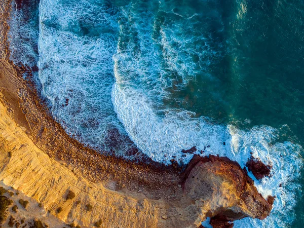 Aerial top view on rock cliffs and waves — ストック写真