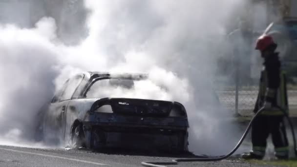 Πυροσβέστες Σβήνουν Ένα Φλεγόμενο Αυτοκίνητο Στο Δρόμο — Αρχείο Βίντεο