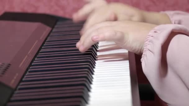 電気ピアノで遊んでいる子供の手の近くのビュー — ストック動画