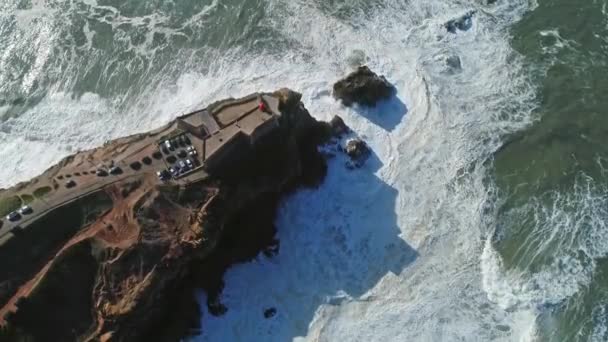 大西洋岸の要塞と崖の上の灯台の空中トップビューは ナザレ ポルトガル 4Kの大きな波で — ストック動画