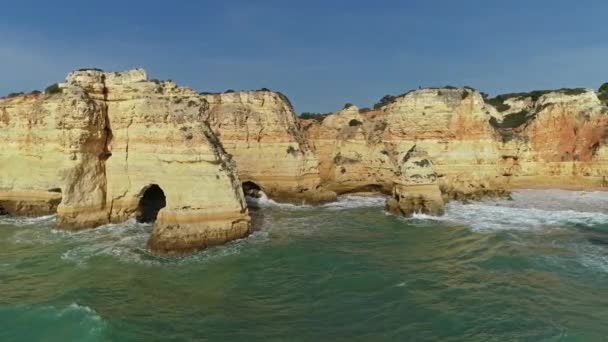 アルガルヴェ ポルトガル 4Kのプライア マリーナ近くの岩崖や波の空中ラウンドビュー — ストック動画