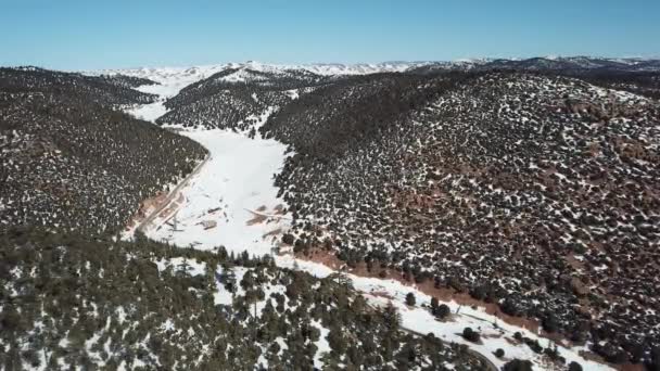 雪に覆われたアトラス山脈の道路の空中ビュー冬 4Kでモロッコの森に覆われた — ストック動画