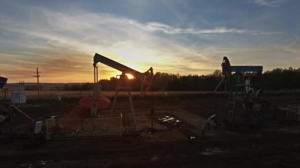 Flying near working oil pumps at sunset — Stock Video