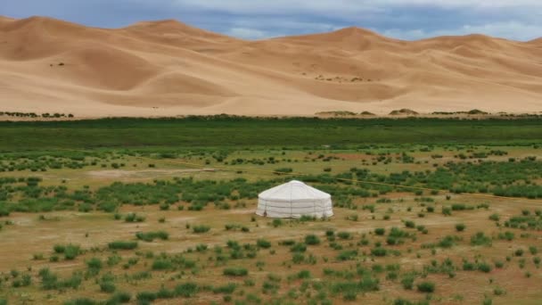 Воздух вокруг вид на юрту возле песчаных дюн — стоковое видео