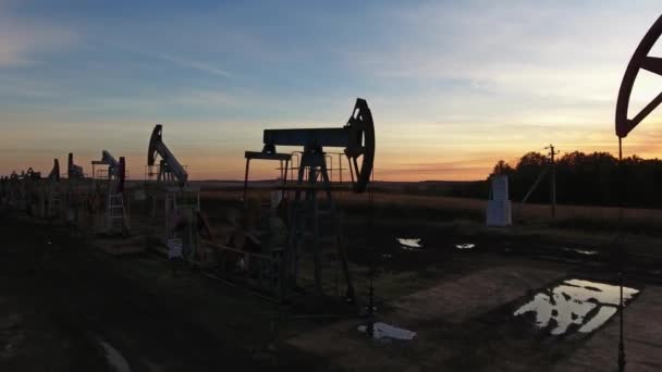 Voando perto de bombas de óleo de trabalho ao pôr do sol — Vídeo de Stock