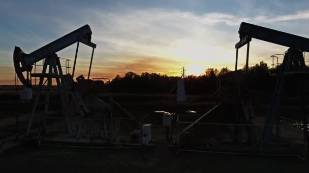 Flying near working oil pumps at sunset — Stock Video