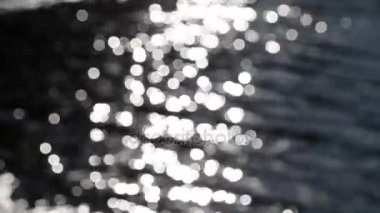 Odak dışında güneş kamaşma bokeh suya yansıyan.