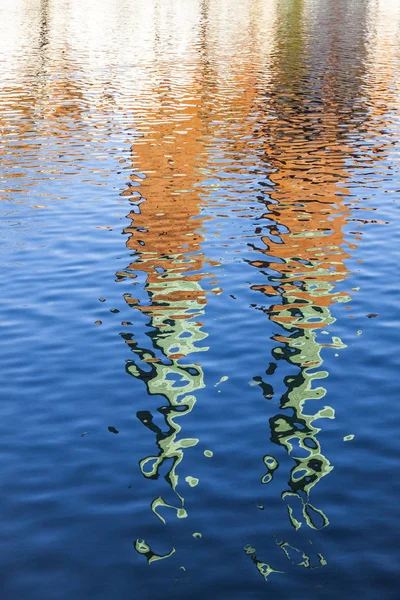 Towers of Catholic Church reflected in a river — Stock Photo, Image