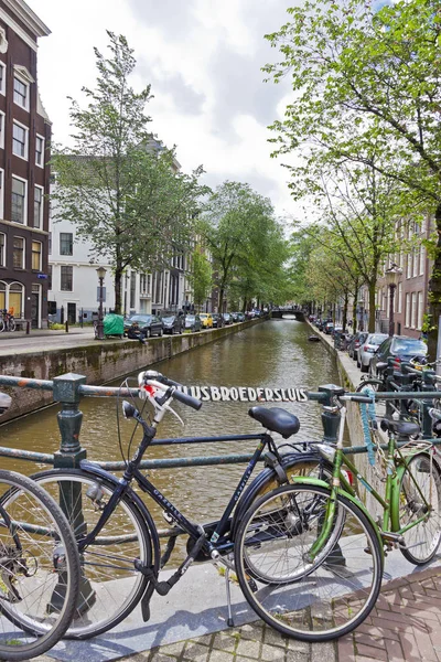 Fietsen geparkeerd op Paulusbroedersluis brug in Amsterdam — Stockfoto