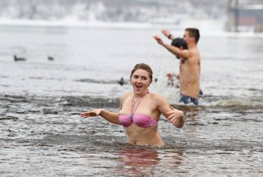 İnsanlar İsa'nın doğuşu kutlamaları sırasında buzlu suya daldırma