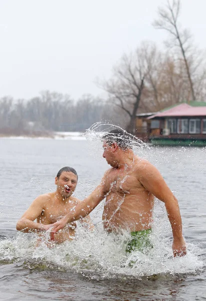 Люди погружаются в ледяную воду во время празднования Богоявления — стоковое фото