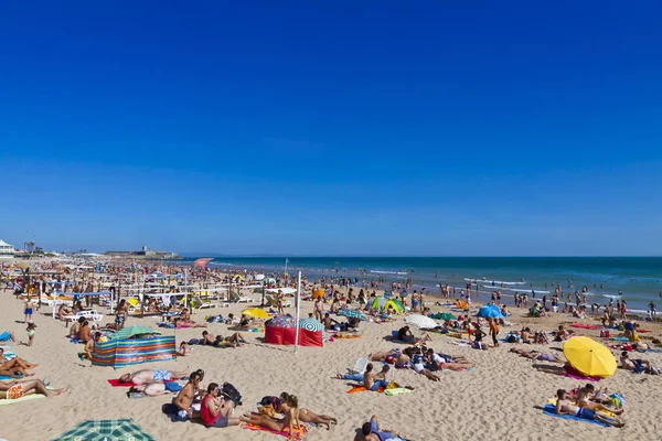 Personas tomando el sol en la playa atlántica de Carcavelos, Portugal — Foto de Stock
