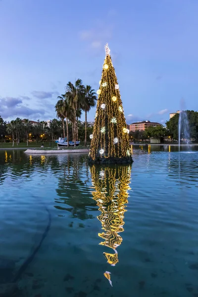 Árvore de Ano Novo decorada iluminada refletida na água — Fotografia de Stock