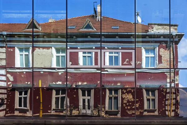 Πρόσοψη του παλιού κτιρίου αντανακλάται στα παράθυρα του σύγχρονου ξενοδοχείου — Φωτογραφία Αρχείου