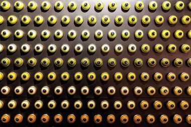 Siyah bir duvara dizilmiş renkli boya kutuları.