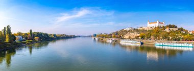 Slovakya 'nın Bratislava kentindeki Tuna Nehri' nin panoramik manzarası. Bratislava Kalesi sağ tarafta. Güneşli bir sonbahar günü