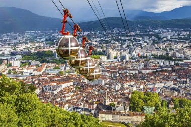 Picturesque aerial view of Grenoble city, Auvergne-Rhone-Alpes region, France. Grenoble-Bastille cable car on the foreground. French Alps on the background clipart