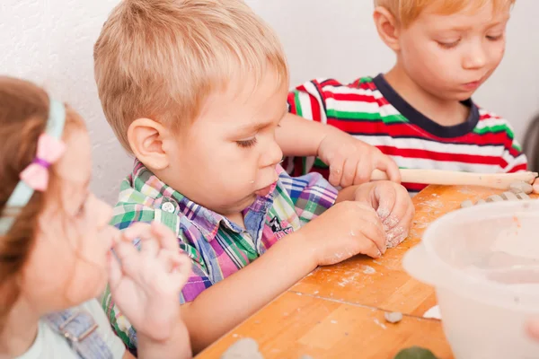 Glückliche Kinder beschäftigen sich mit Modelliermasse — Stockfoto