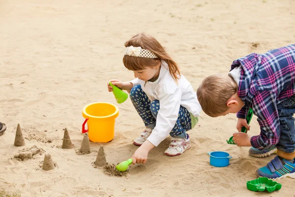 Niños jugando en una caja de arena — Foto de Stock