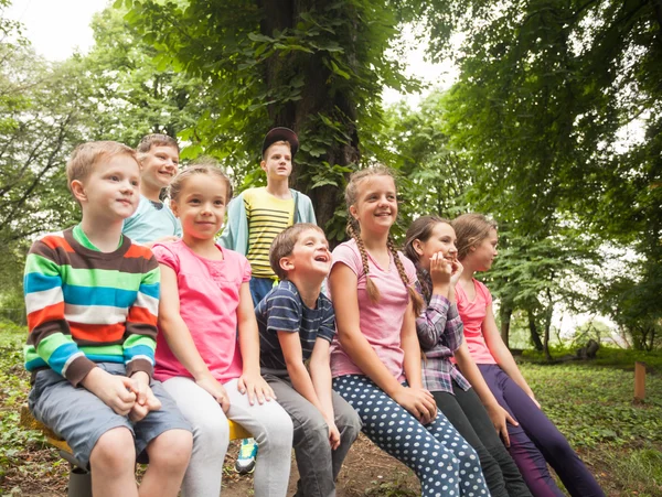 Grupo de crianças em um banco de parque — Fotografia de Stock