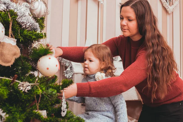 Mamma och dotter dekorera julgran — Stockfoto