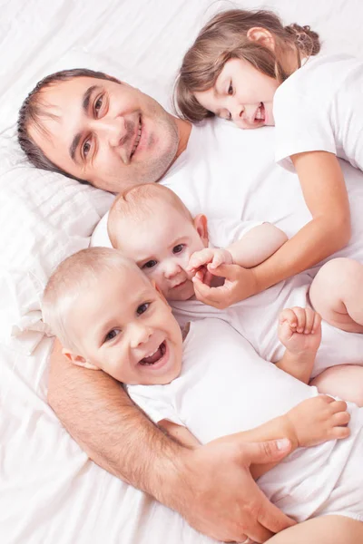 Portrait of a father with children on the bed — Stock Photo, Image