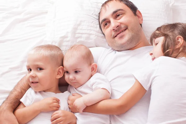 Портрет отца с детьми на кровати — стоковое фото