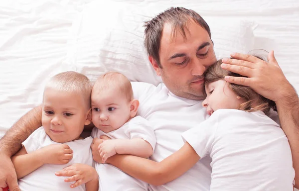 Portrait of a father with children on the bed — Stock Photo, Image