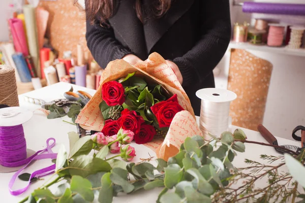 Florist making  bouquet of red roses — Stock Photo, Image