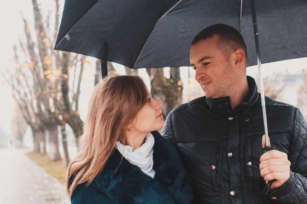 Jovem casal sob um guarda-chuva — Fotografia de Stock