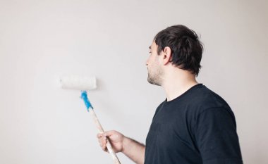 Adam beyaz bir duvar boyaları
