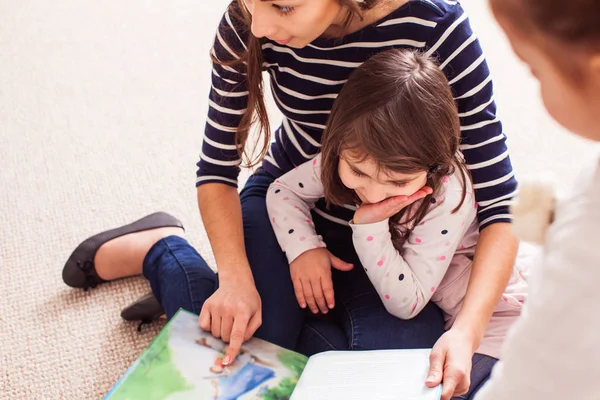 Mamma med dotter läsa en bok — Stockfoto