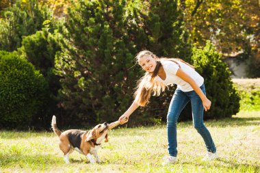 Kız bahçede bir köpekle oynar