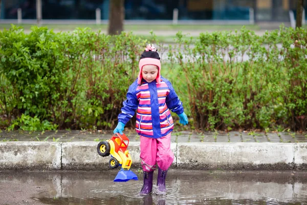 Little girl playing in the puddle — Stock Photo, Image