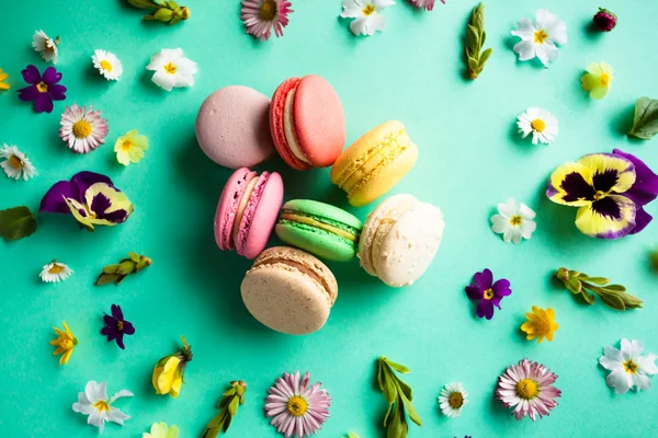 Kleurrijke bitterkoekjes en bloemen — Stockfoto