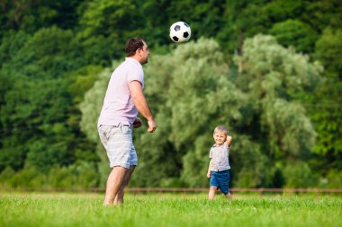 Baba oğul futbol oynuyor.