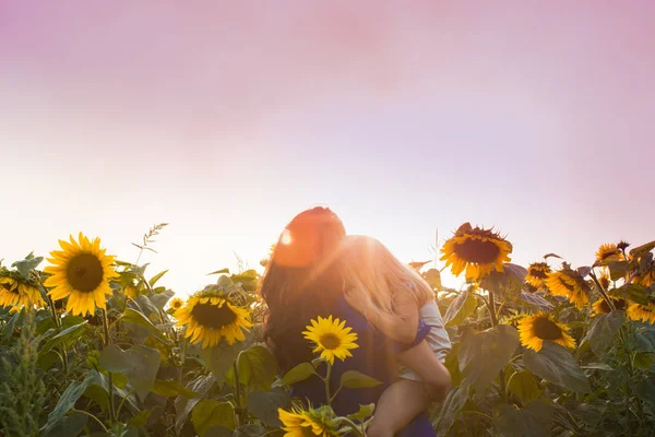 Mutter und Tochter zwischen Sonnenblumen — Stockfoto