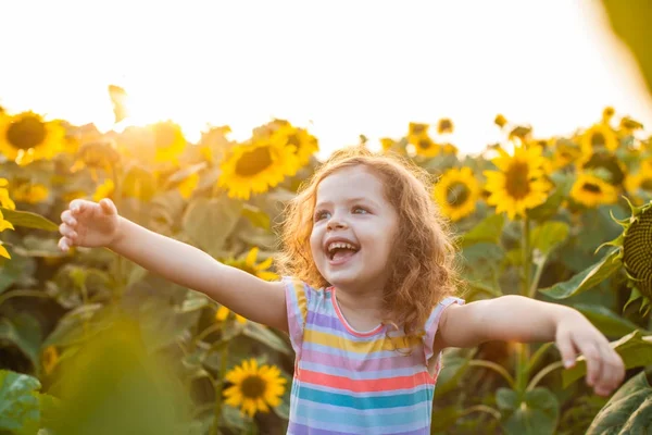 Happy girl is fond of sunflowers — Stock Photo, Image